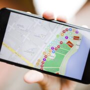 Persona sosteniendo un telefono con navegacion de mapa y ubicacion de tienda
