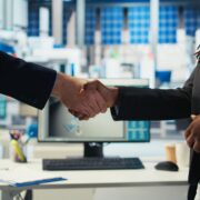 Empresarios colombianos cerrando acuerdo comercial en planta industrial